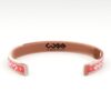 Bracciale in rame di colore rosso con logo ripetuto (retro)